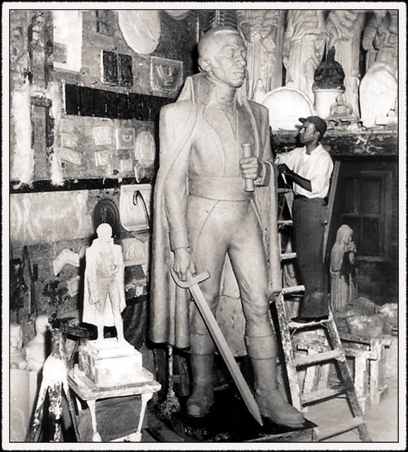 A man working on the Toussaint L'Ouverture sculpture
