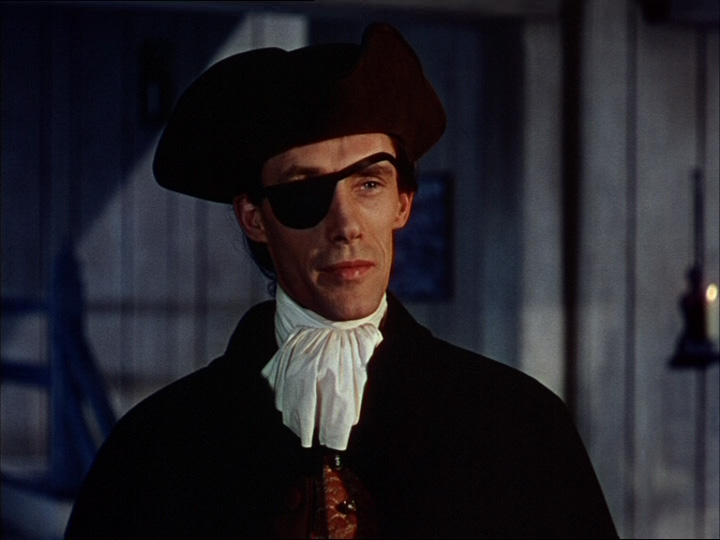 Movie screen shot of man wearing an eye patch and black hat. 