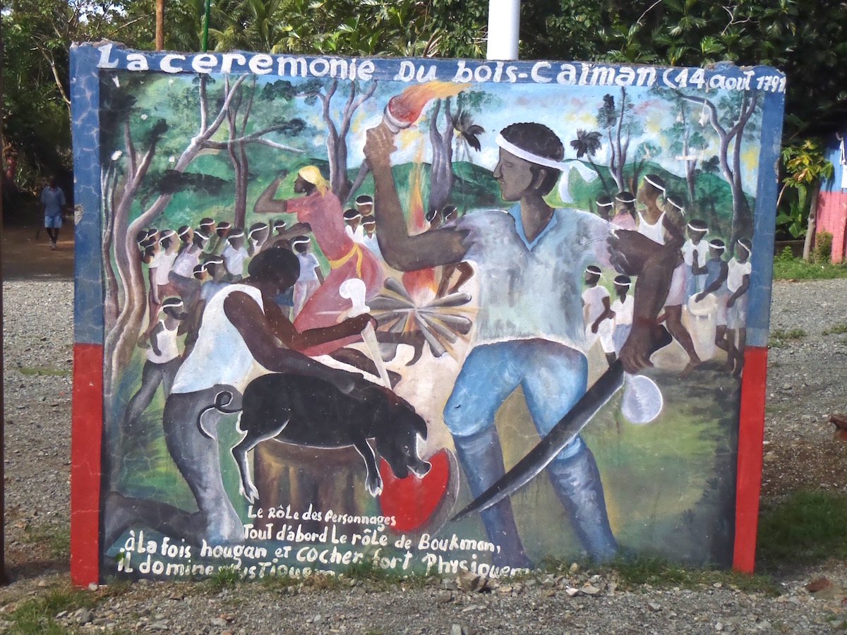 Mural representing two men killing a pig in front of a crowd.