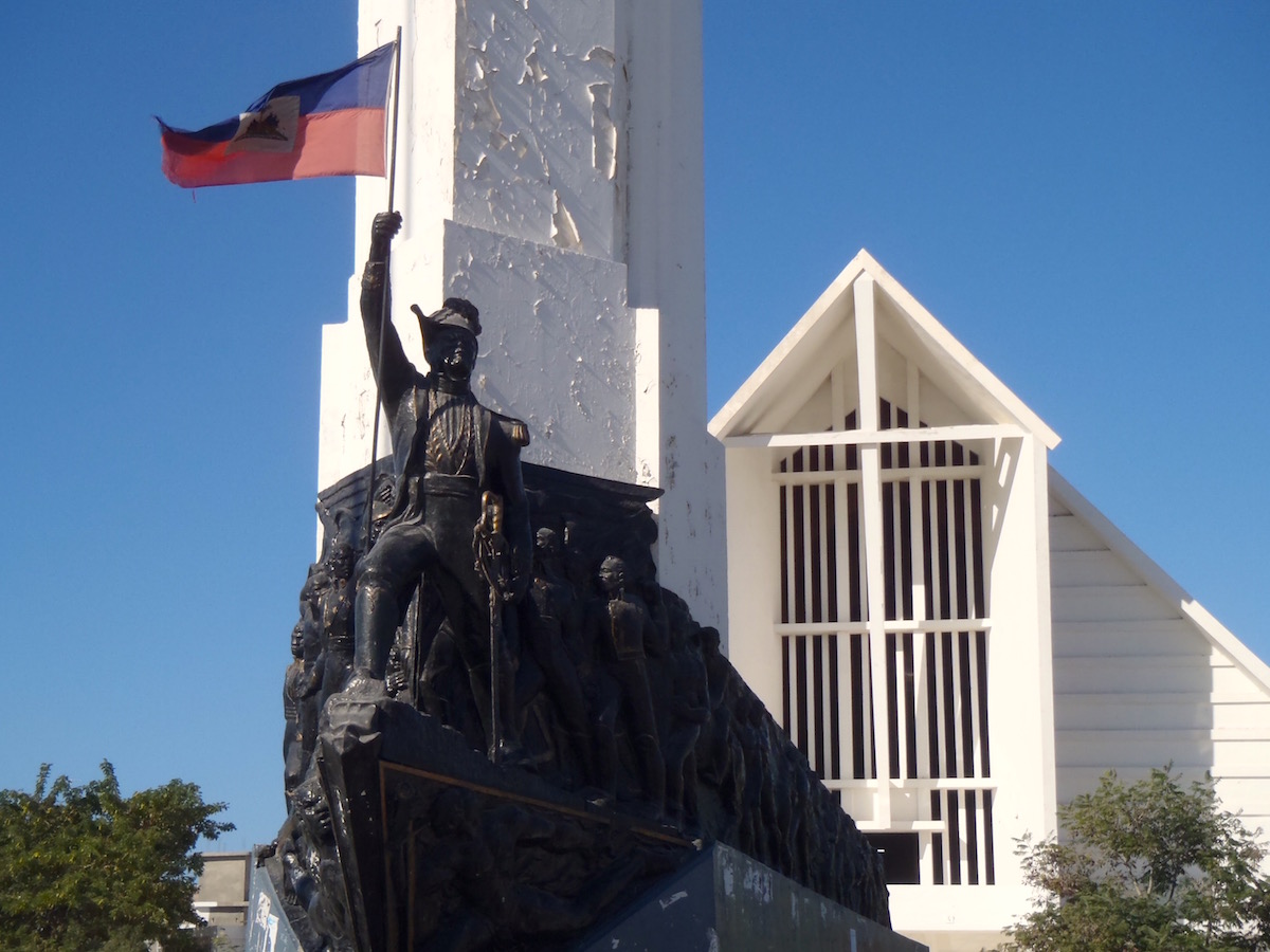 Sculpture of Dessalines holding a Haitian flag.