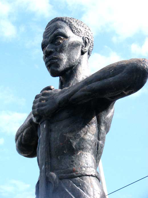 Statue of Paul Bogle standing up with his hands on his chest.