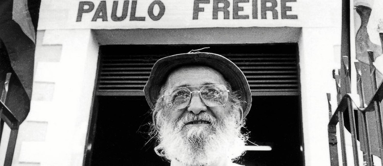 Picture of Paulo Freire in front of a building with his name on it.