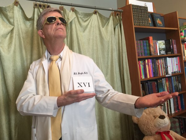 A student dressed in a lab coat with the the number sixteen on the pocket. 