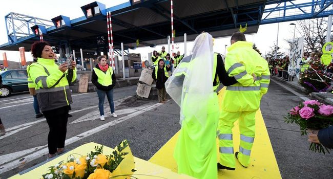 A man and a woman in a marriage ceremony wearing bright yellow outfits. 