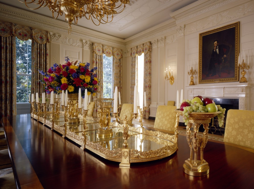 A large gilded bronze plateau on a dining room table.