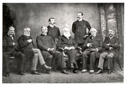 The seven executive officers of the American Historical Association sitting in a row with two standing in the back, posing for a photograph.